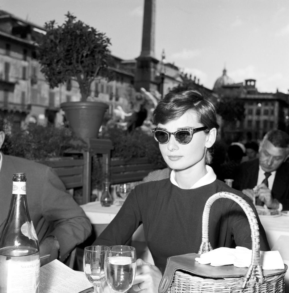best of audrey hepburn on X: audrey hepburn (and her basket purse) at a  café in the piazza navona. rome, 1955  / X