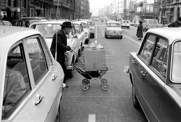 Un anciano empuja su carrito, cargado con regalos navideños, entre los coches retenidos por el atasco que se producía en la calle de Alberto Aguilera de #Madrid , hace 50 años. #EFEfototeca