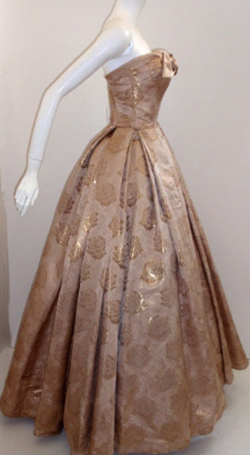 LaurenCDeutsch's tweet photo. Today's #ootd is this 1950s Don Loper strapless evening gown. It's made of what I think is metallic gold brocade and features a lovely bow on the bodice. We actually have the measurements for this one, it's 34 in bust, 26 in waist, and 39 in hips. #1stbids #fashionhistory https://t.co/VQDyUXyLJG