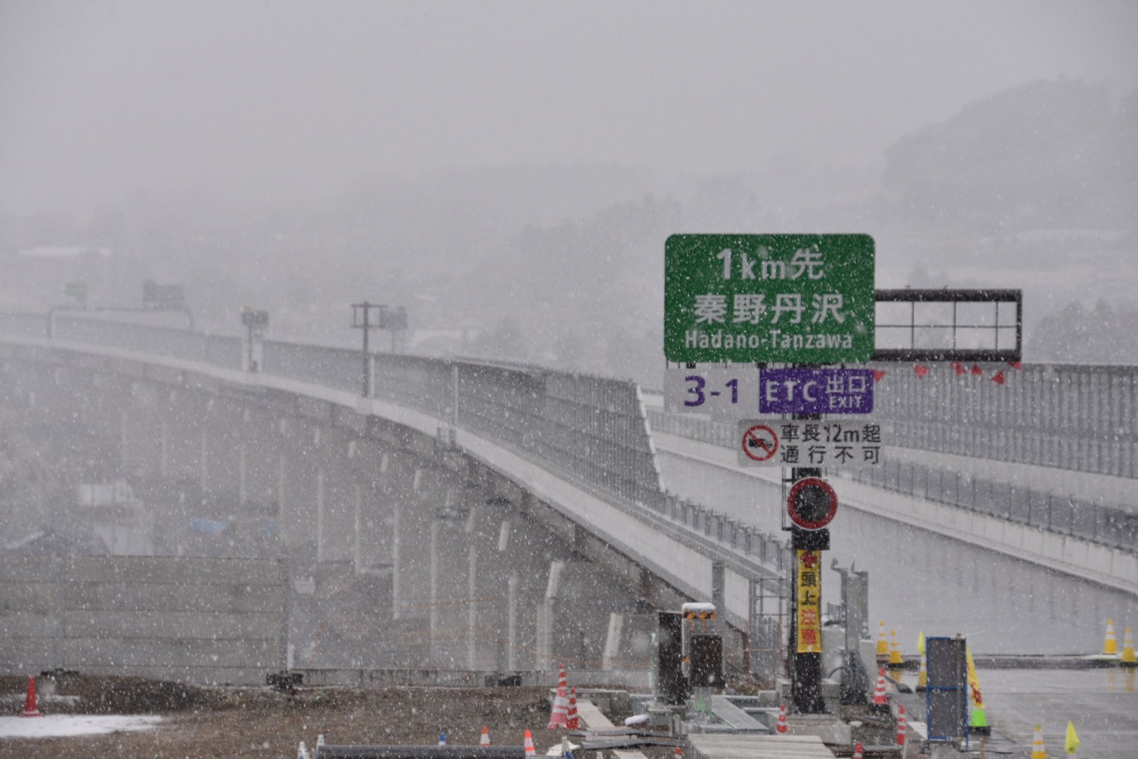 秦野市 今日は寒さが厳しいですね 午前中から降り始めた雪は 午後になるとだんだんと強くなり 車や屋根にうっすらと積もってきました 3月に開通予定の新東名高速道路の秦野丹沢sic工事現場の周りも本降りです 視界が悪くなっていますので 外出の際