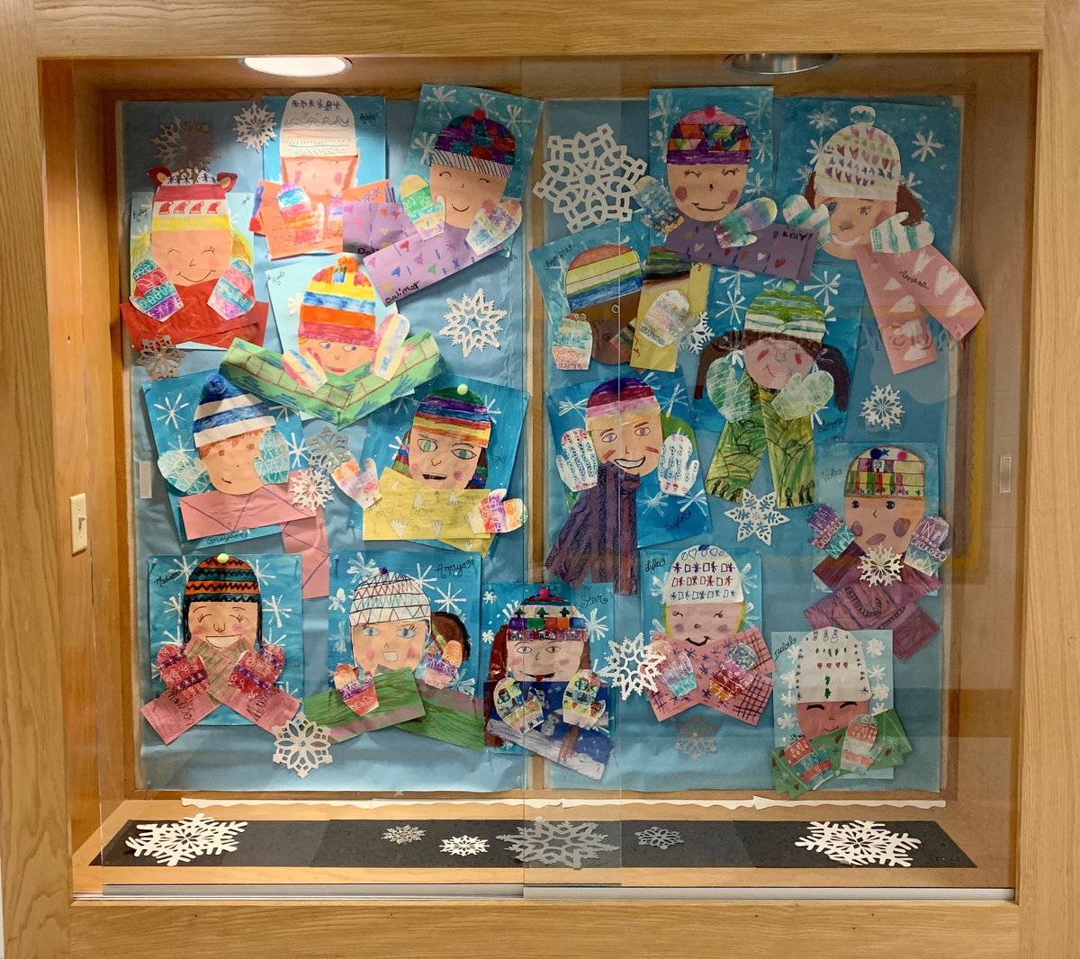 Winter Self Portraits by 2nd grade. These second graders were so patient through the long process of making each part of this artwork and learning how to print, stamp, mix a tint of blue and work with pastels for patterned scarfs and finally making their self portrait!