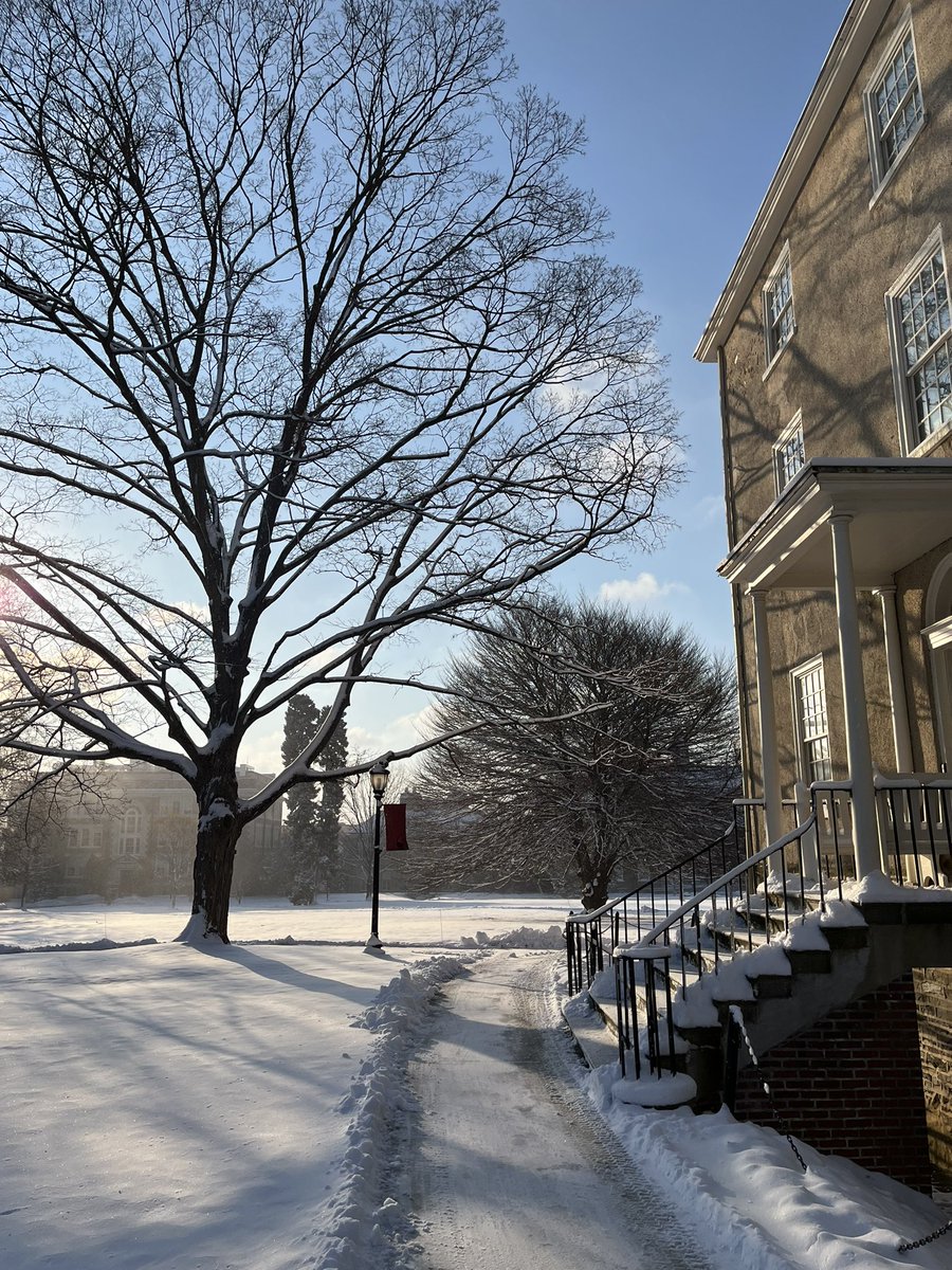 The sun rises behind Sharpless and the side stairs of Founders are covered in snow.