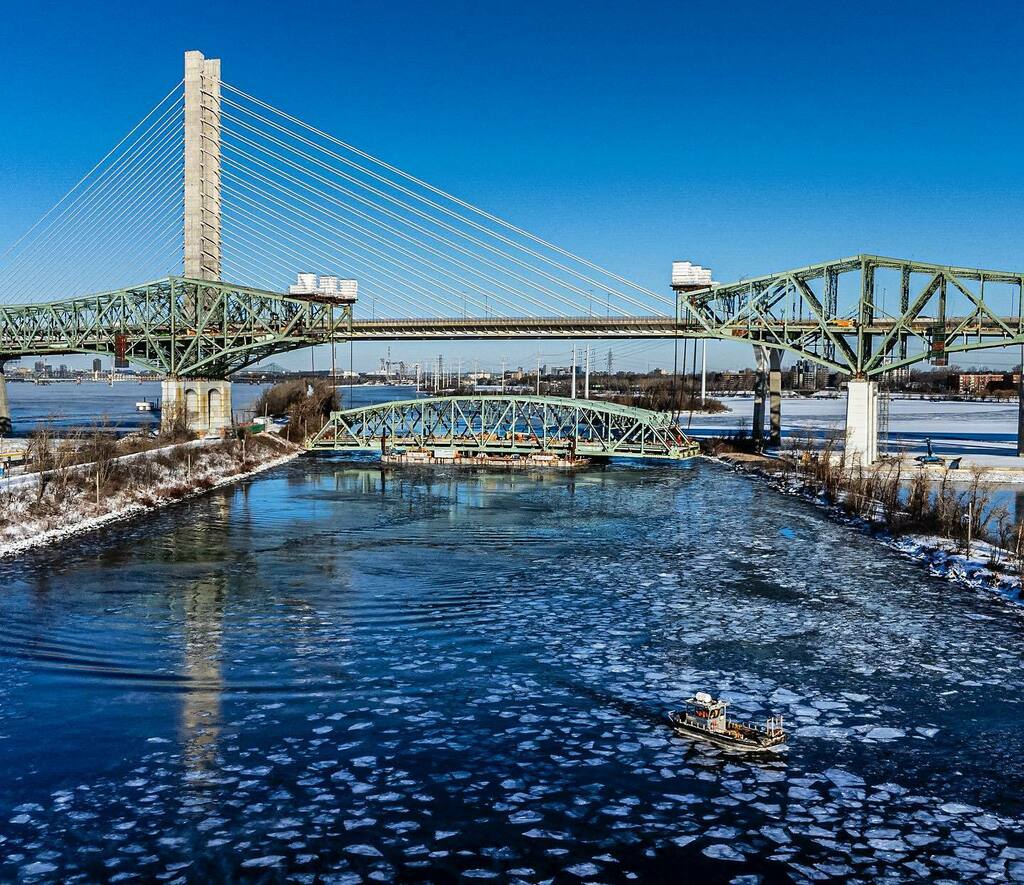 dsidaway's tweet photo. The dismantling of the old Champlain Bridge continues. Yesterday the crew lowered the 2,200-tonne, 117.5-metre centre span 33 metres to water level onto two barges and today they turned it 90 degrees by tugboats and began pushing it upstream to a landing… https://t.co/AD3cq86YBd https://t.co/yWNZJKfBD5