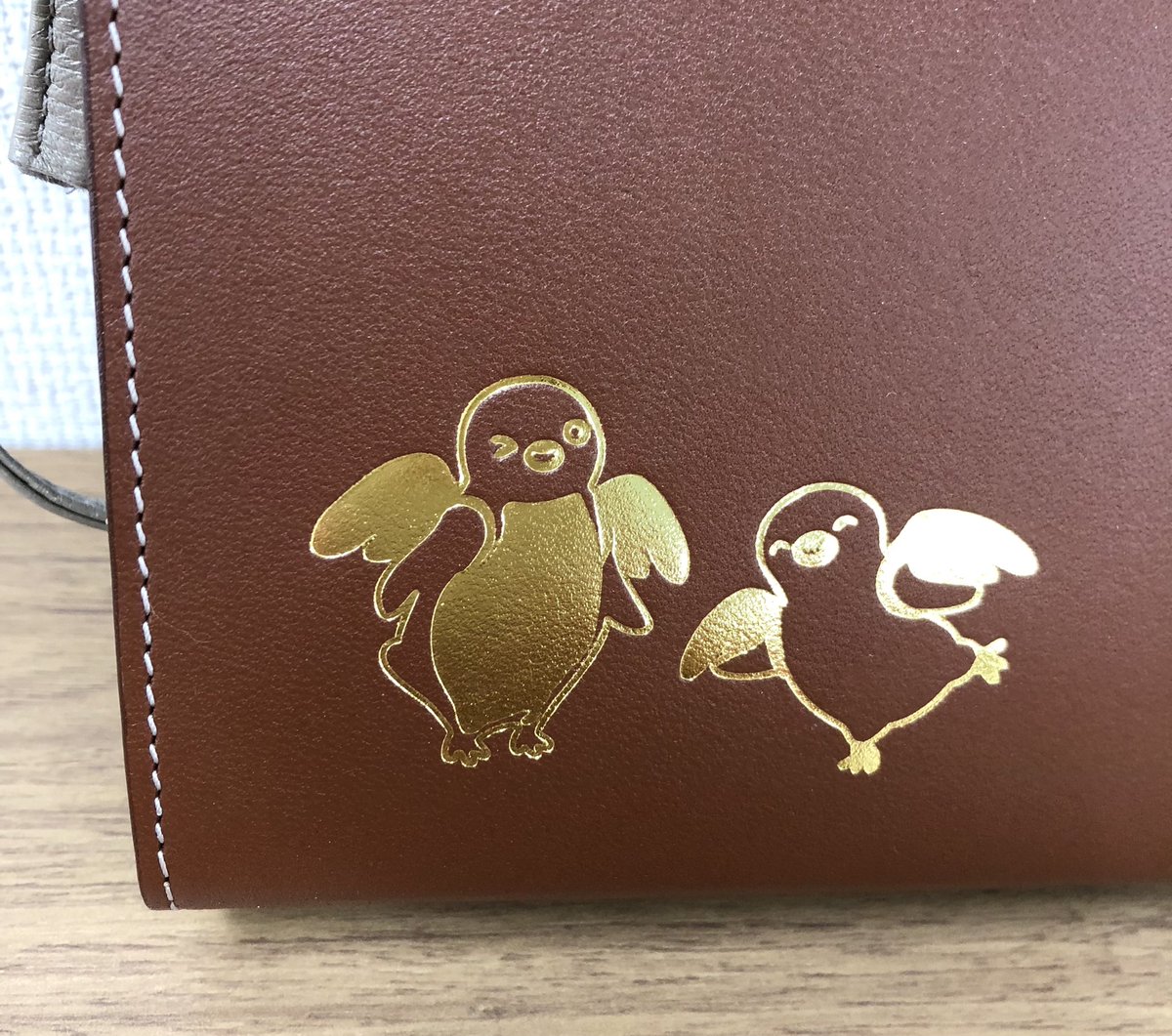 TrainOrangepage's tweet photo. エンジェルペンギン金箔押しの【本革ポシェット】はブラウン✖️グレーの配色が大人っぽい〜💕。内ポケット1つで、肩がけはもちろん、斜めがけも可能♪  トレニアート東京&amp;吉祥寺、トーキョーみっつでは1/13木曜から、オレンジページ通販は1/17月曜から（※送料無料予定）発売です🧡 https://t.co/gNH825OjDT