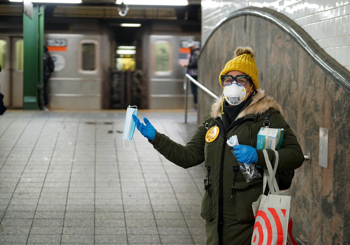 A volunteer offers a free mask at the Atlantic Av-Barclays Ctr subway station.