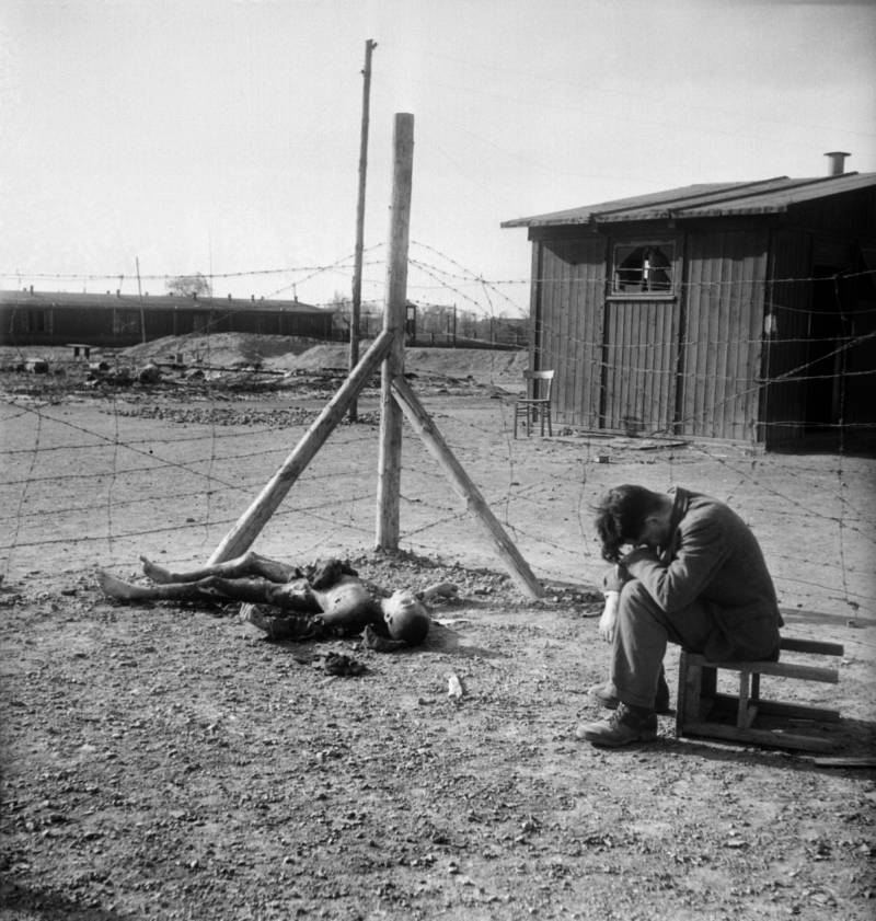 StephenUzzell2's tweet photo. Young man sits on an overturned stool next to a burnt body inside the Thekla concentration subcamp outside Leipzig, Germany soon after its liberation by U.S. forces on April 18, 1945.

ERIC SCHWAB/AFP/Getty Images https://t.co/oYlmMHwxPf