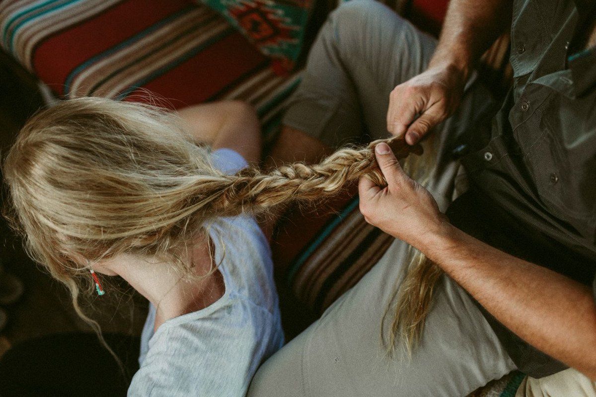 Cassian trançando o cabelo dela