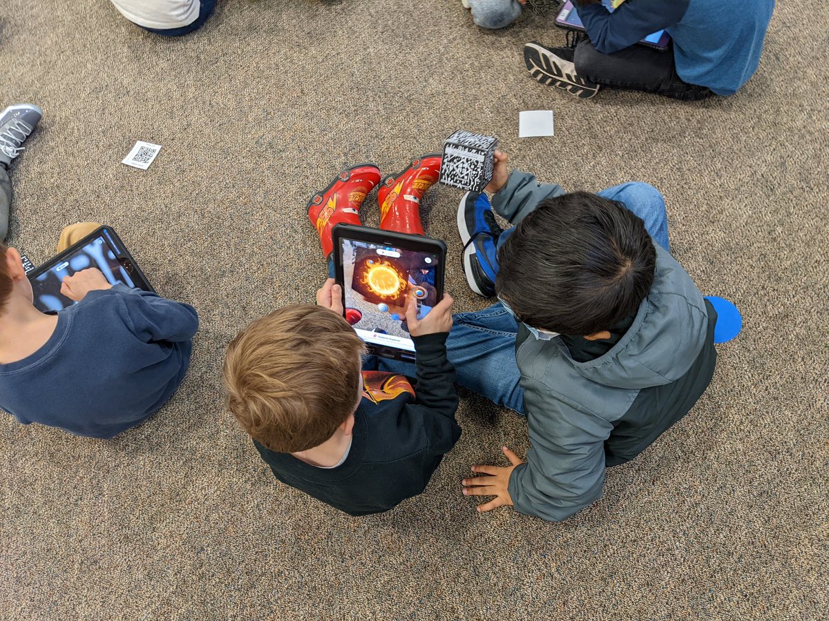 Timberslibrary's tweet photo. What do you do when you have two kindergarten classes in the library for specials? @MergeVR cube to the rescue! Our classes loved listening to @RJPalacio's We're All Wonders with @Novel_Effect and exploring the solar system in AR with #MergeExplorer. @HumbleISD_TE @HumbleISD_DDI https://t.co/uxyrTighc6