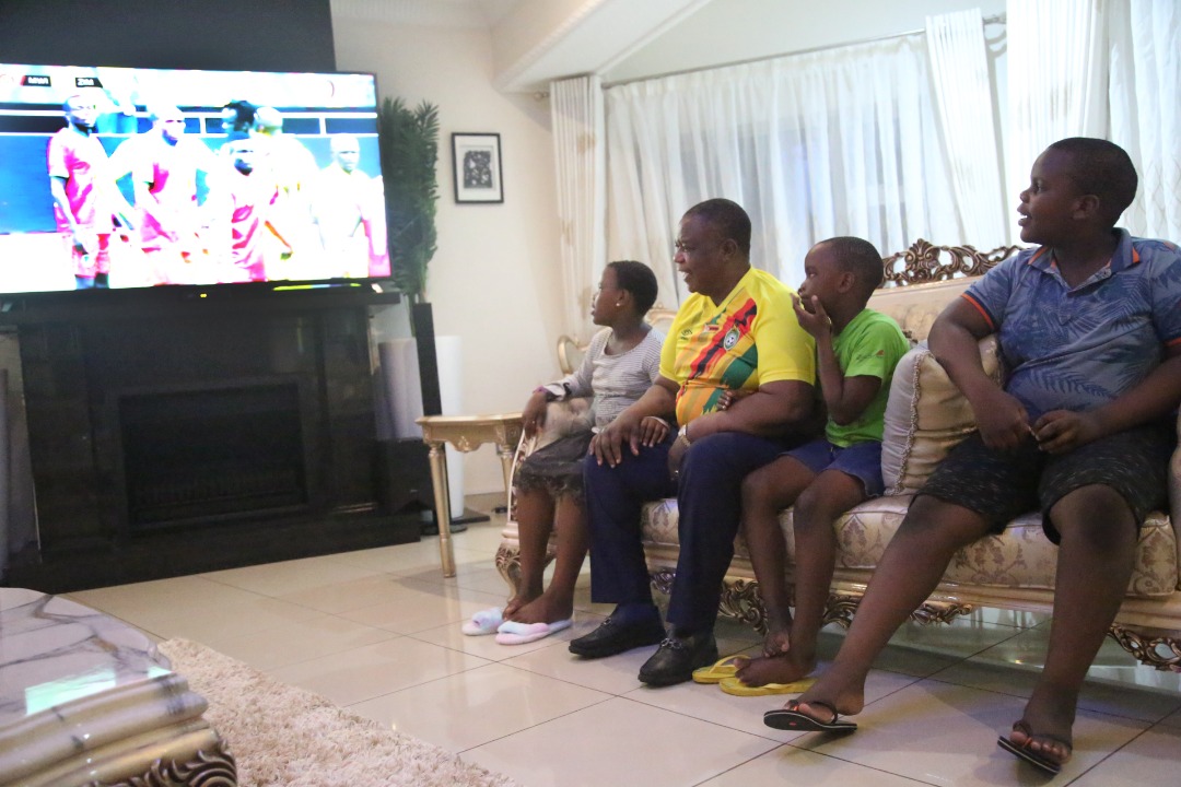 Vice President Constantino Chiwenga and his family watch Warriors play against the Flames of Malawi from his home in Harare this evening.