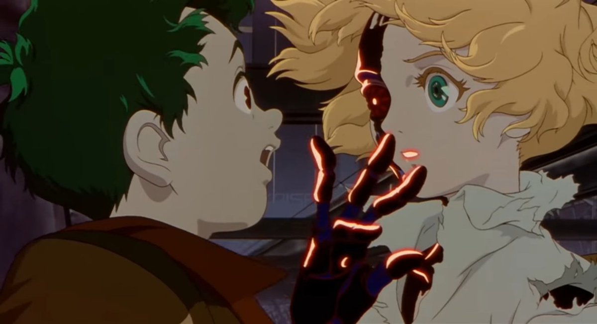image from the end sequence of the anime film Metropolis (2001), showing the two central characters facing each other, a dark-haired young man and a blonde young woman whose right hand and the right side of her face are made of exposed glowing mechanical parts, revealing that she is an android