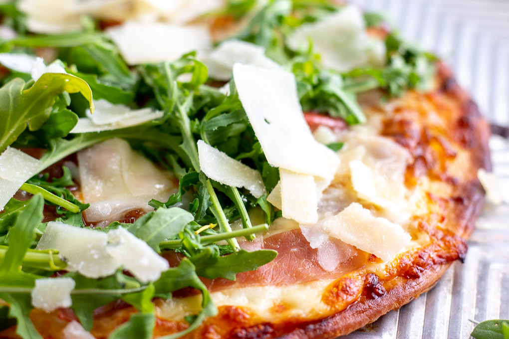 Amp up your holiday table with this super easy Prosciutto Arugula Flatbread. Simple ingredients,