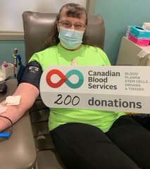 Photos of Josephine Michaluk  in a donation bed holding a Canadian Blood Services sign with 200 donations and a bouquet of lovely flowers. 