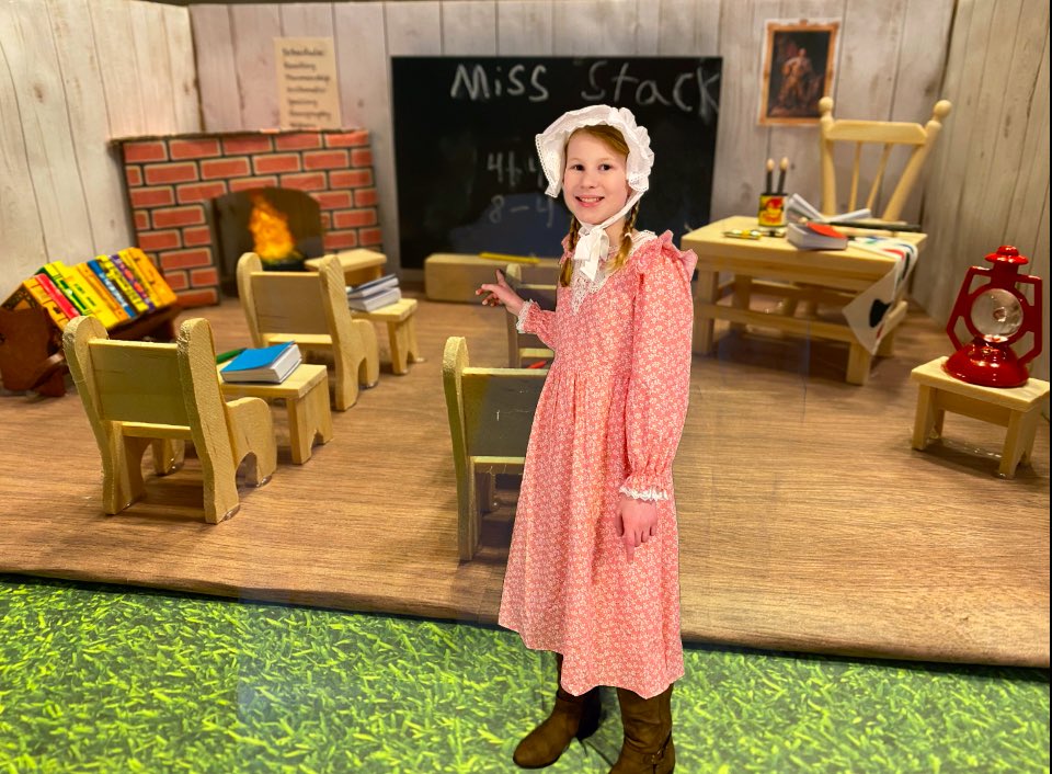 MrsMStack's tweet photo. It’s colonial project/presentation time. This colonial schoolmaster is ready to teach her class all about going to school in the 1700s and had some fun inserting herself in her diorama with the green screen today! #aNAISing https://t.co/B64whUhT7e