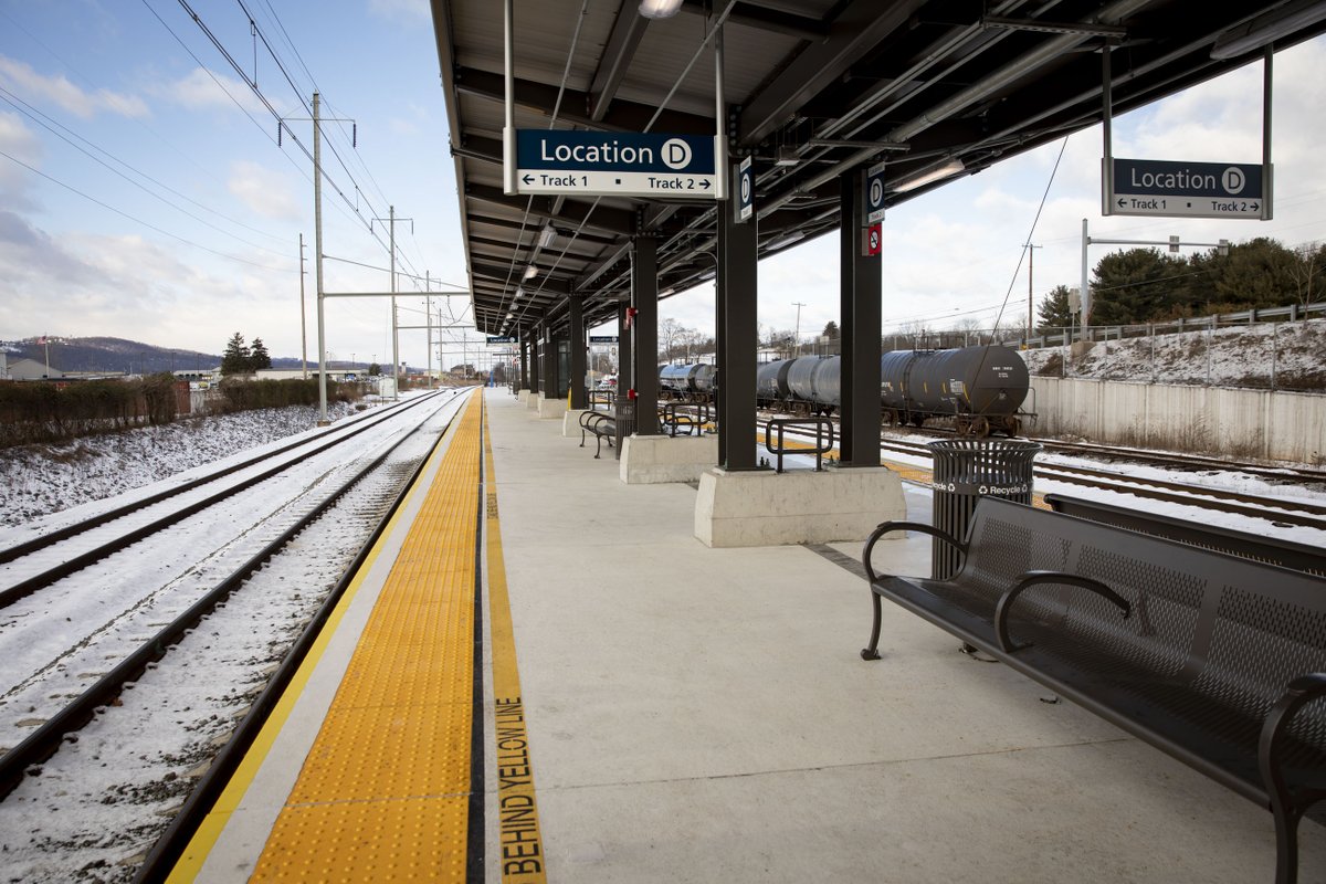 Tracks and benches for people to sit while waiting for their train.