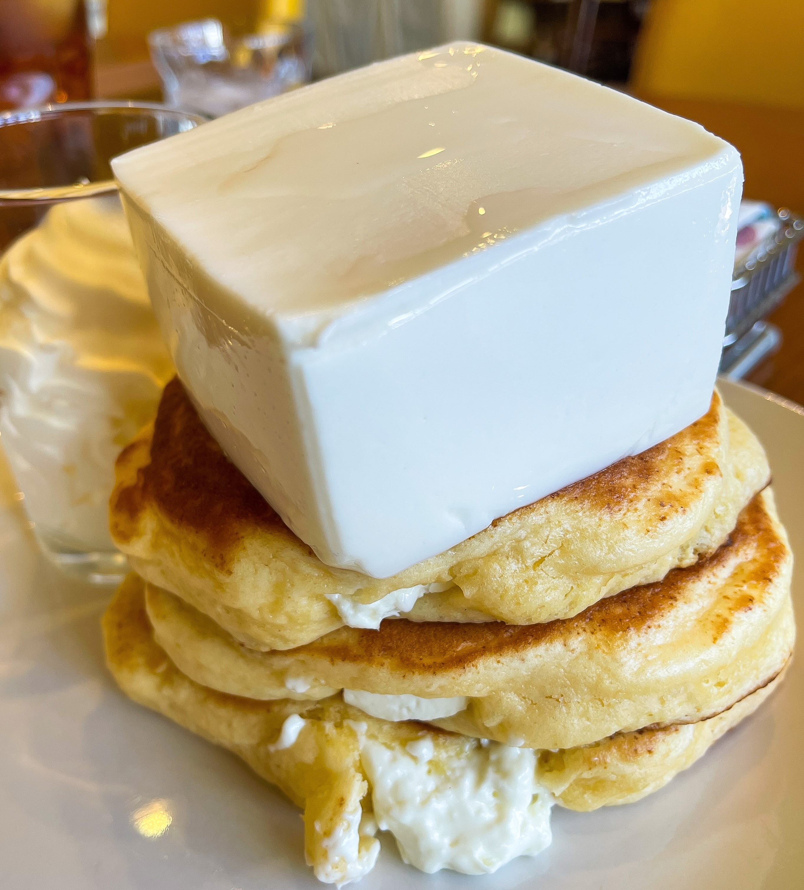 唯一無二の絶品グルメ むにぐるめ クリームチーズパンケーキは1430円 パンケーキ3枚重ねで巨大チーズが載っているのでボリュームも抜群 メープルシロップが添えてあるので チーズと合わせることで甘じょっぱい風味で楽しむことも可能です T