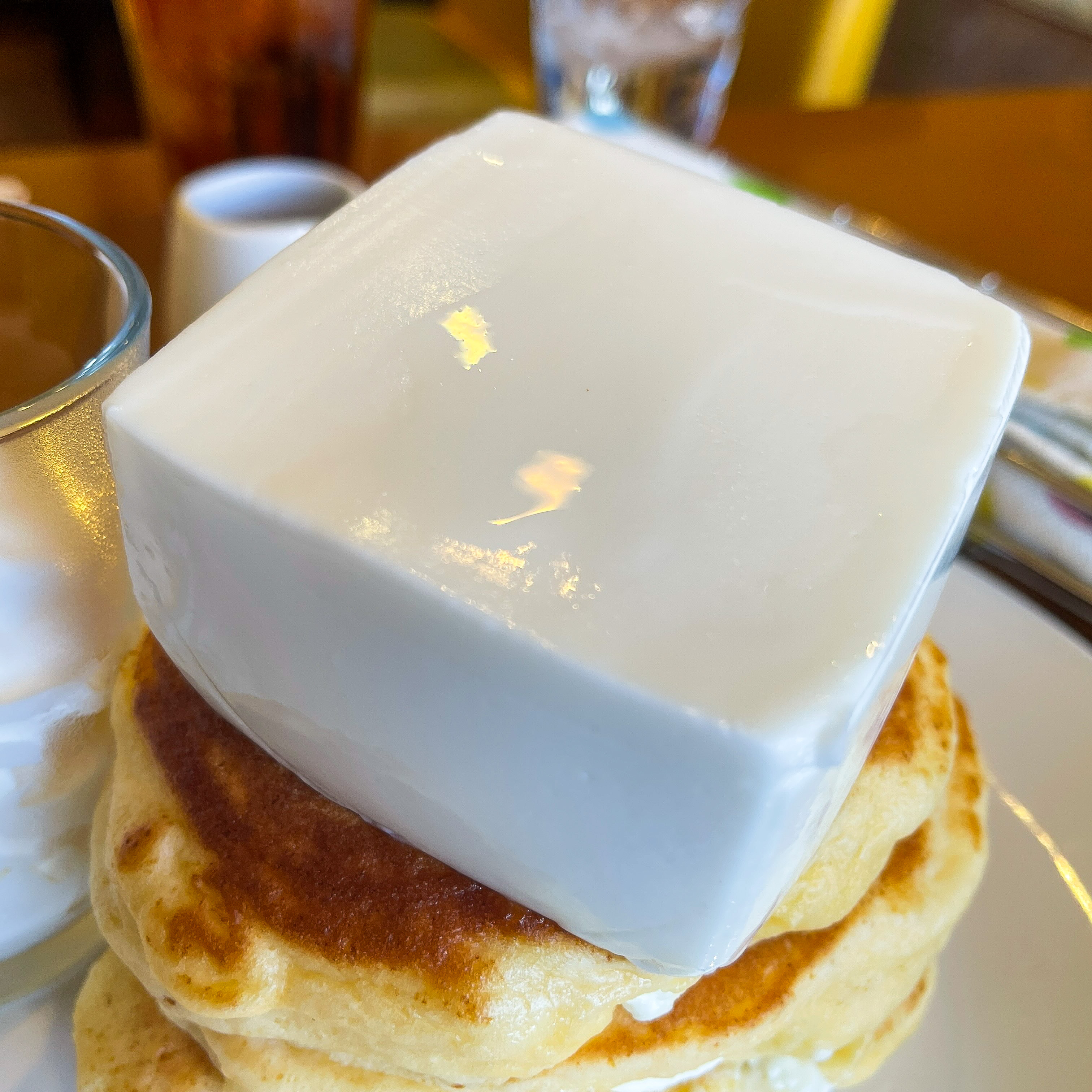 唯一無二の絶品グルメ むにぐるめ クリームチーズパンケーキは1430円 パンケーキ3枚重ねで巨大チーズが載っているのでボリュームも抜群 メープルシロップが添えてあるので チーズと合わせることで甘じょっぱい風味で楽しむことも可能です T