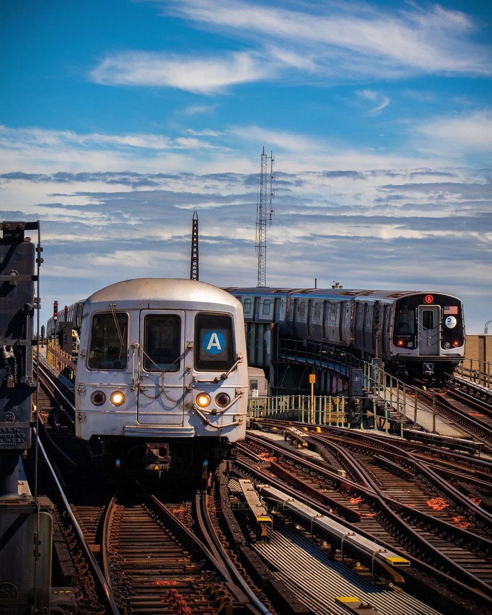 An R46 and R179 A train headed in opposite directions east of Rockaway Blvd station in Queens.