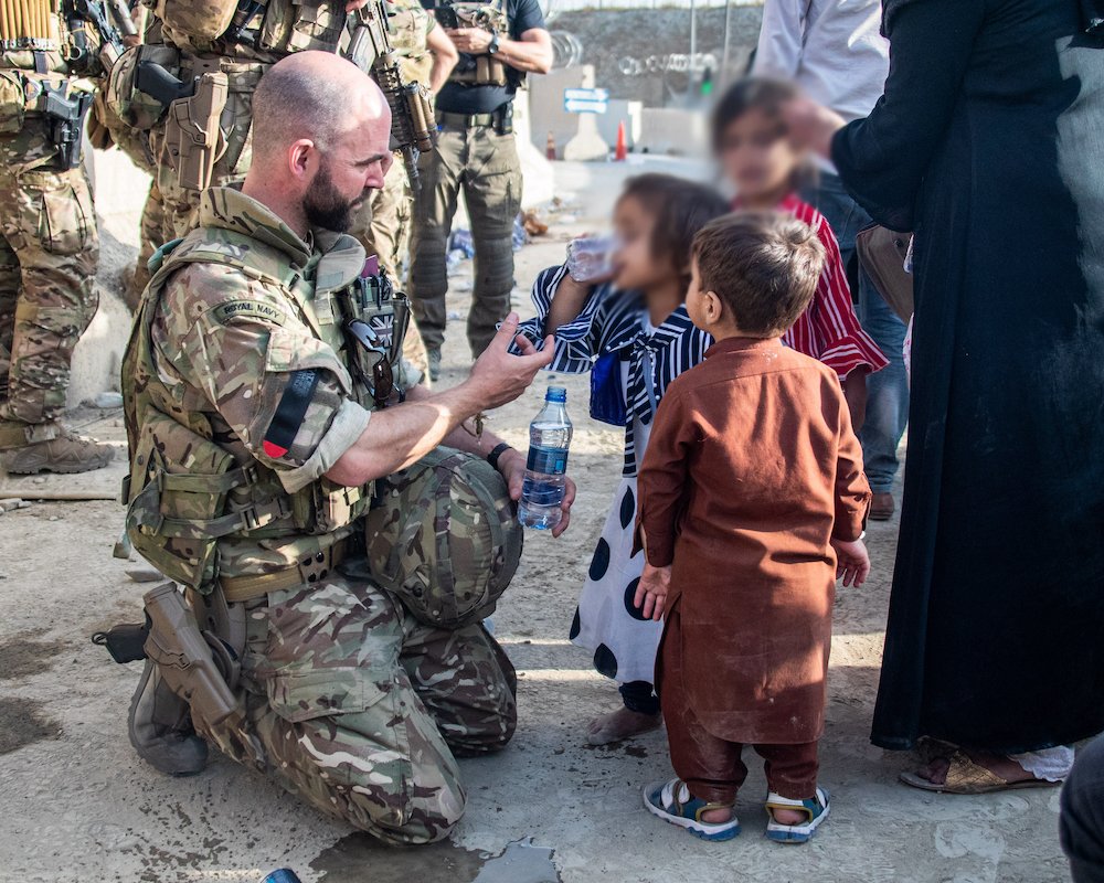 Image shows personnel helping children in Afghanistan on Operation PITTING.