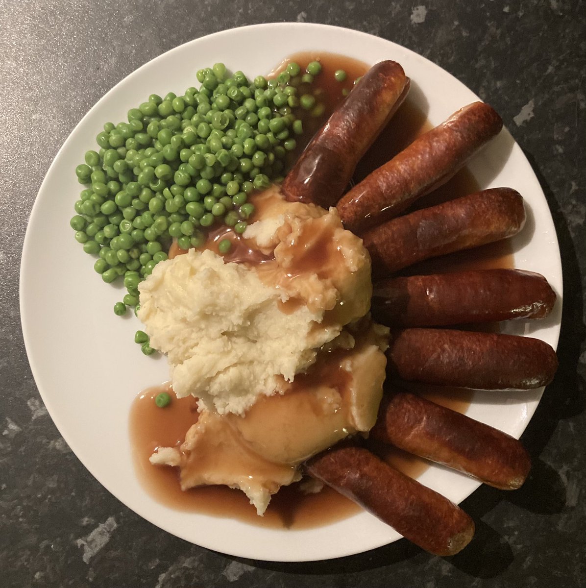 Sausages suckling on a belly of mash watched over by vegan peas with a drizzle of sustainably sourced non vegan gravy #Mmmm
