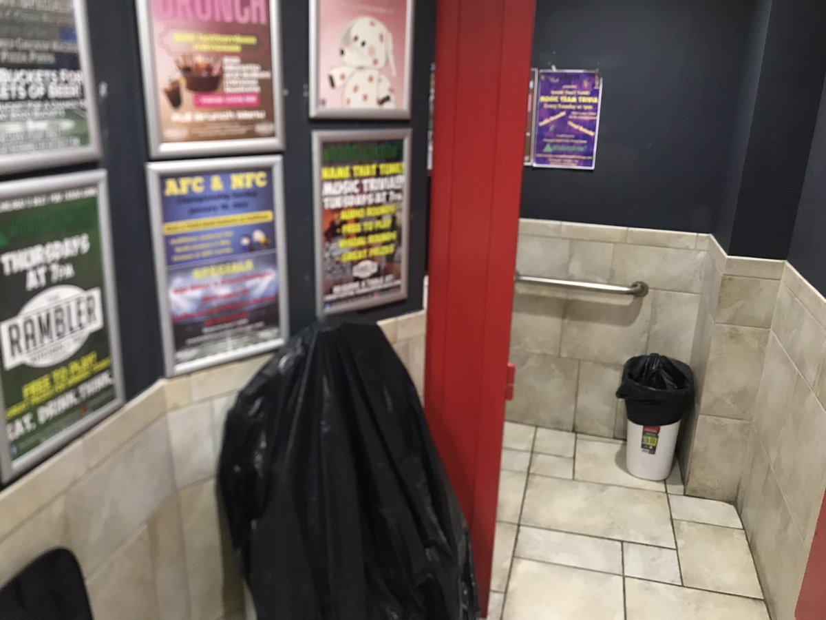 Men’s bathroom <a href="/theramblerchi/">theramblerchi</a>. +1 for having a toilet. -6 for the black plastic bag over the urinal. Pathetic, in my book. -2 for too many advertisements. Good bar though. 3/5.