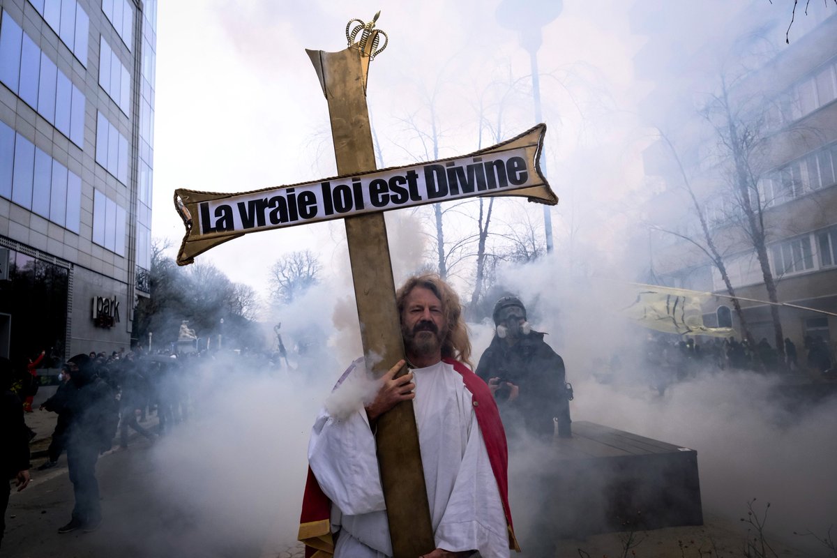 A man holds a cross as police confronts protestors during a demonstration against COVID-19 measures in Brussels, Belgium on Jan. 23, 2022. #Bruxelles #BRU2301 #Manifs22janvier #Brussel #Jesus