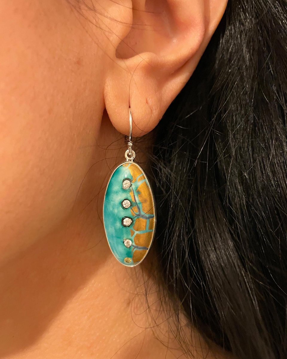 Su Yolu tasarım Küpe ile görünümüne asalet kat. 925 ayar gümüş ve seramik ile elle tamamlanan, ışıltılı zirkon taşlara sahip küpelerde sır üstü 18A altın uygulandı. Sevginin gücünden iham alan bu kullanışlı küpeler her görünüme ışıltılı bir dokunuş katacak.