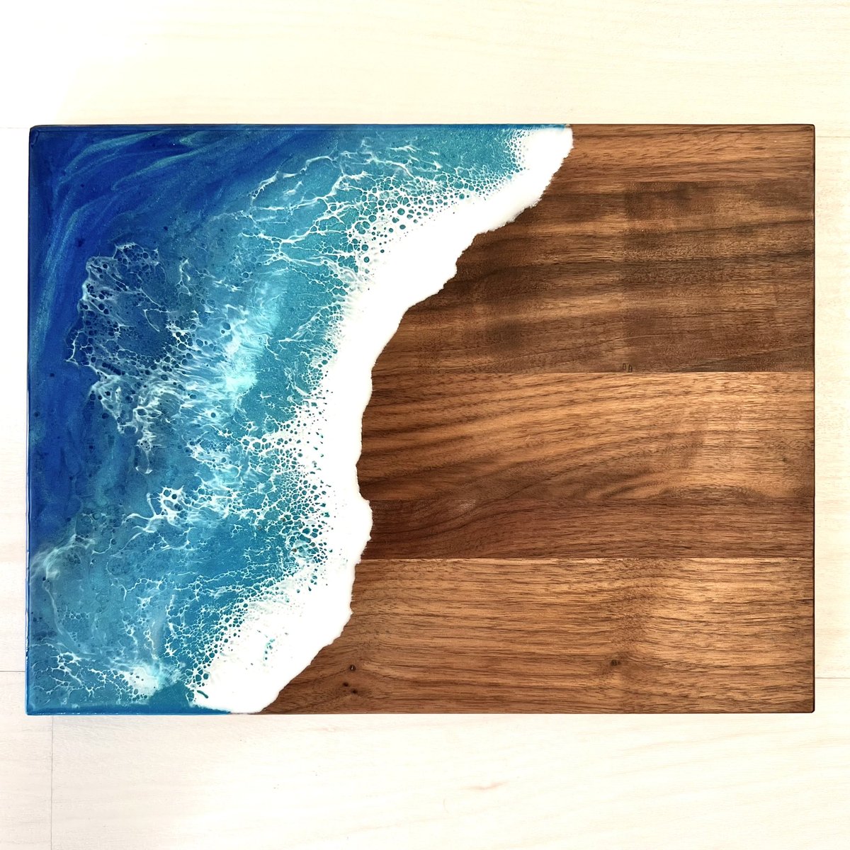 budobotm's tweet photo. I think I’m starting to prefer the single wave 🌊

This is my small ocean resin charcuterie board on walnut! You should always hand wash this and use food grade wood wax to prevent stains. 

#oceanresin #charcuterieboard #giftideas https://t.co/cjNYW738sX