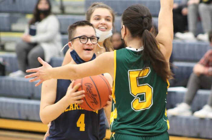 FOR THE LOVE OF THE GAME: Michael Stroster looks to make a basket while sneaking in a smile as the Clarkston Unified Basketball team started its season last Thursday at home against Birmingham Groves Unified. See more in this week’s print edition!