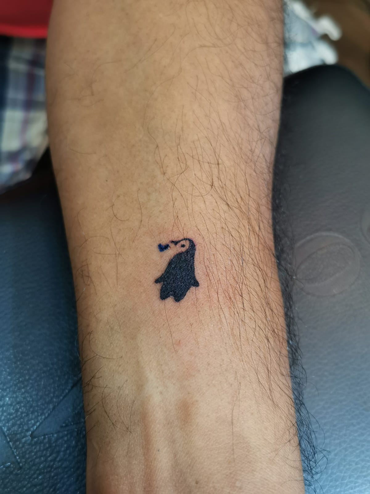 Watercolor penguin tattoo on the ankle