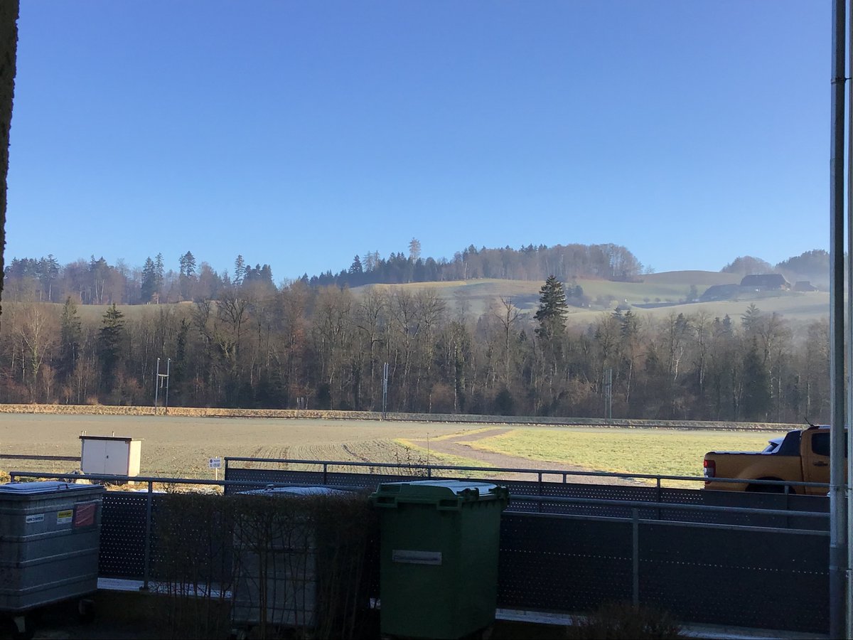 Über den Abfallcontainern erblickte man die Hügel, die das Tal umsäumten.