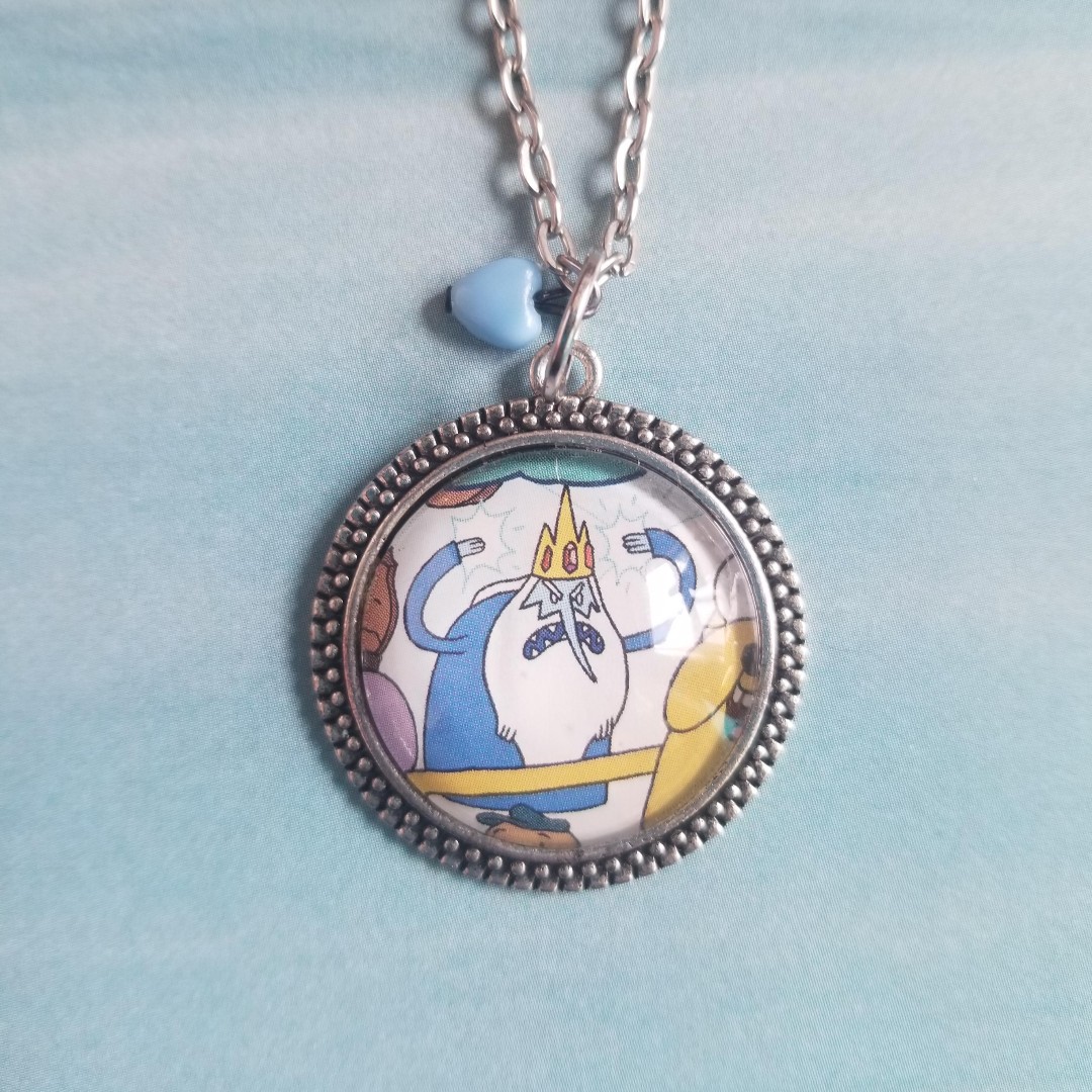 💙 Angry Ice King Pendant Necklace 💙
Upcycled from an Adventure Time comic
Shop Now: etsy.me/3rSDM6b

#adventuretime #iceking #upcycledjewelry #etsyseller #etsyshop #handmadejewelry #fandomjewelry #kidcore #pasteljewelry   #oneofakindjewelry #cartoonnetwork