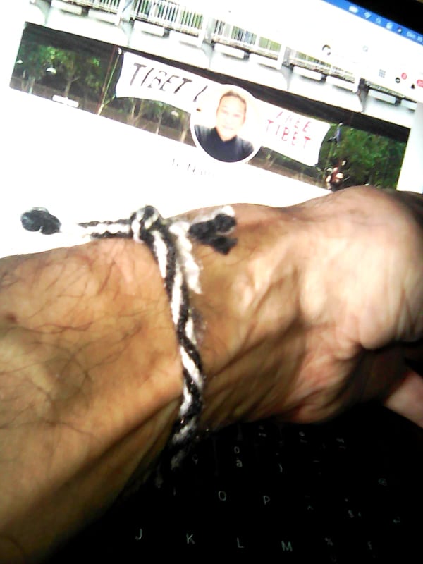Voltuan's tweet photo. Merci à #TeNam de m'avoir offert ( ainsi qu'à mon ami #RaphaelGlucksmann ) au rassemblement appelant au #Boycott des #JO #Pekin #Pekin2022 ce bracelet #Rangzen : "Le Bracelet Rangzen fut tressé par les prisonniers politiques tibétains à partir de leurs vêtements." @la_chouet https://t.co/RrUgZDnzJd