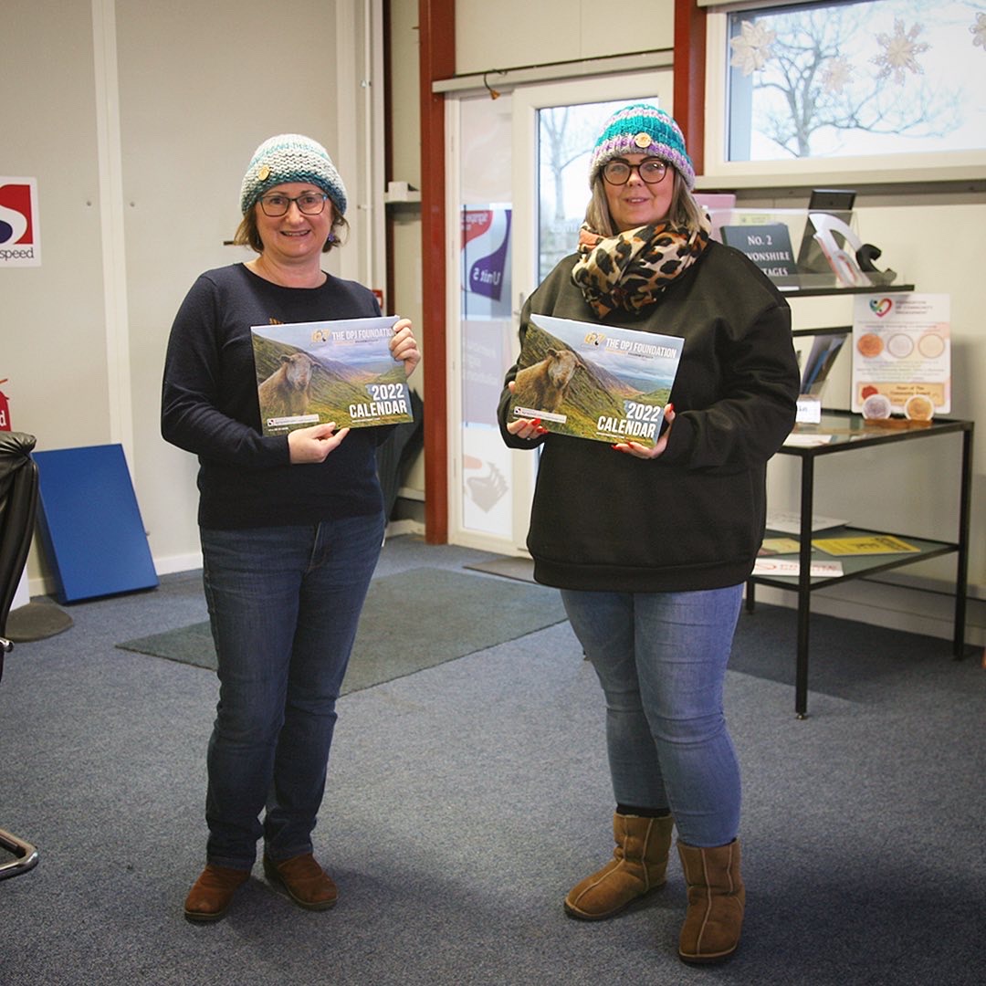 Signspeed's tweet photo. Kay from The DPJ Foundation (left) collecting their 2022 calendars from Sam, our Director (right) back in December (both sporting their DPJ bobble hats!) #sharetheload #rhannwchybaich #shoplocal #supportlocal #designprint #signsdesignprint https://t.co/QPRLOGGg1a