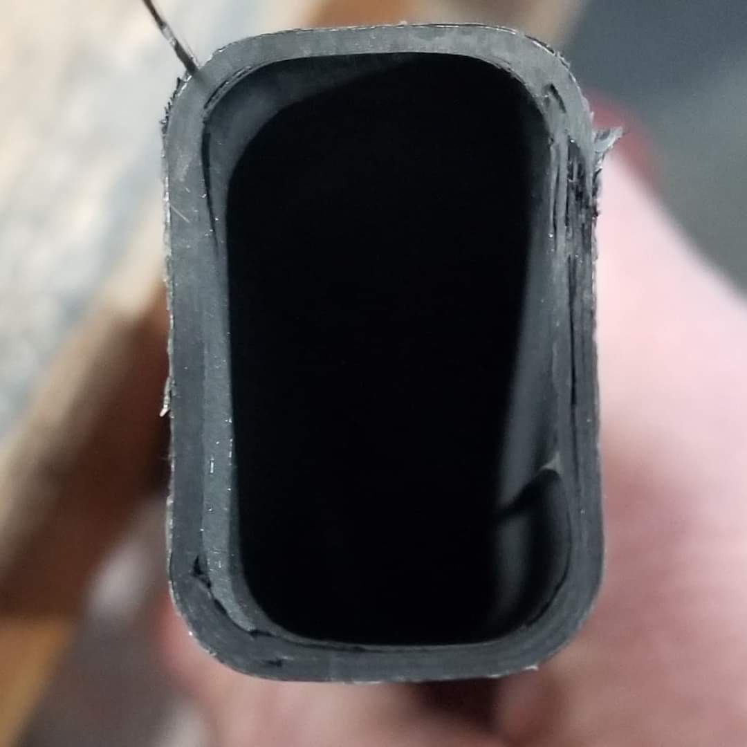 After cutting away broken carbon fiber in an expensive stick, here's what I see. Delaminated layers, possibly created during manufacturing on right side. Weak spot showing delamination in top right and lower left corner.