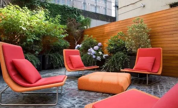 Add more color to your backyard seating area with vibrant throw pillows and cushions. Red and orange are a brilliant combination.