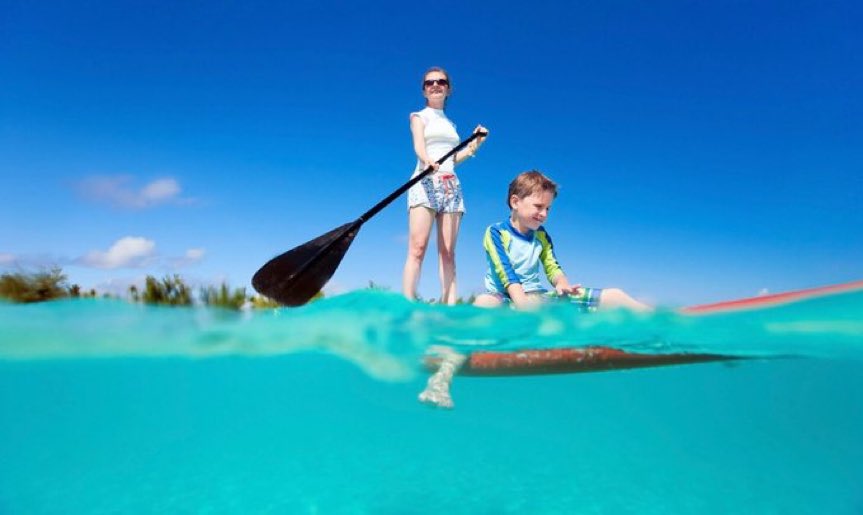 Mother and son on a Stand Up Paddle Board (SUP) in Abaco, Bahamas.