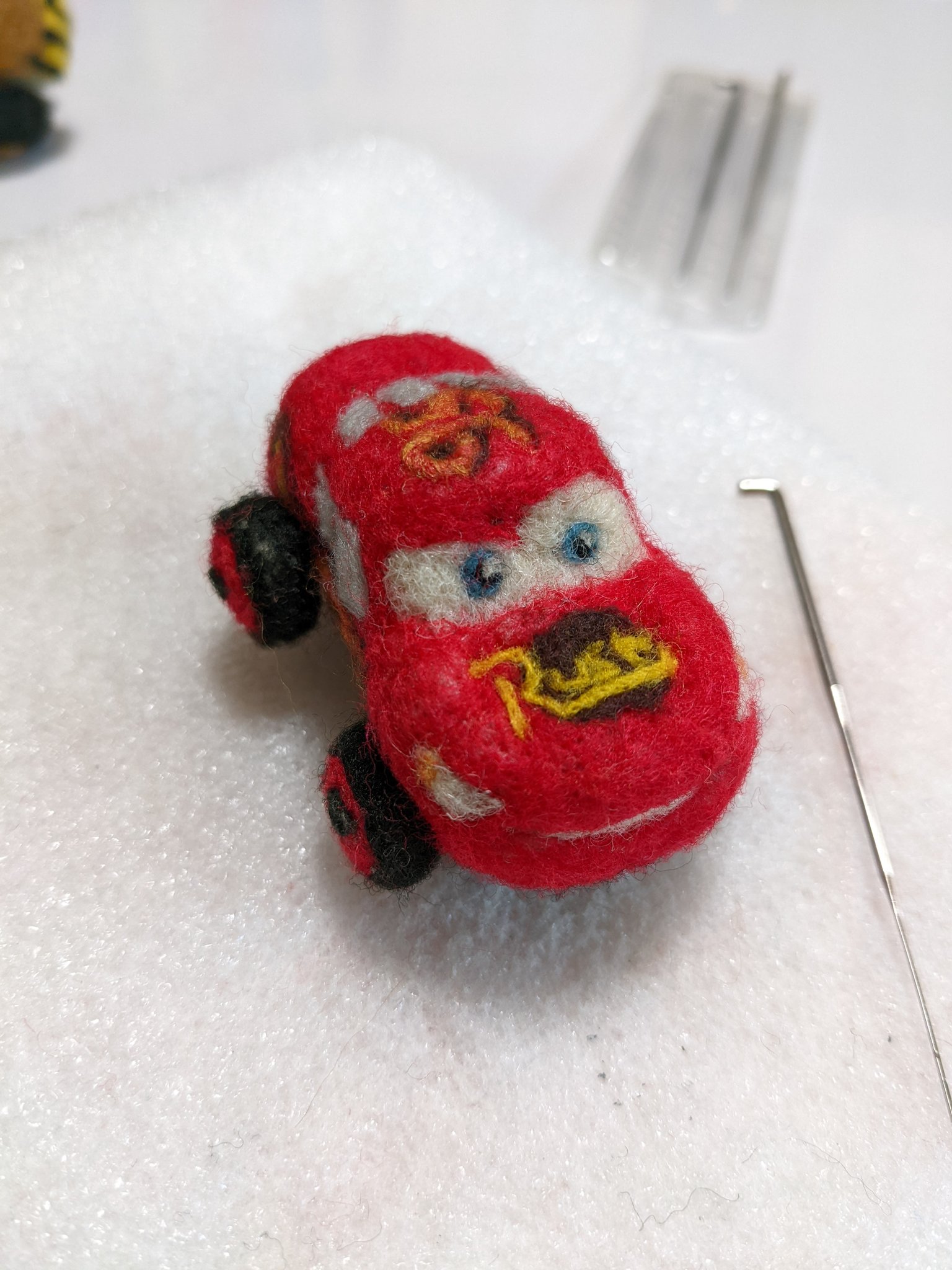 木藤愛 帽子につけてるマックイーン 毛玉だらけになったのを修正 一枚目がbefore 二枚目がafter 男前に戻った しかし タイヤが動く用にストロー芯とかを入れてるの忘れてて 針折るところだった カーズ マックイーン 羊毛フェルト ハンドメイド