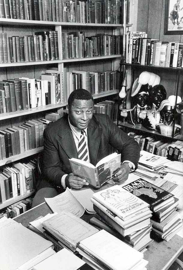 Photograph of Charles Blockson sitting amongst his collection.