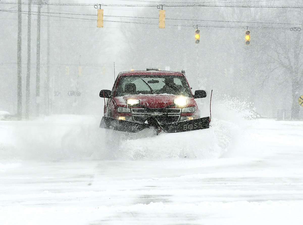 Mike Harvey, of the town of  Chesterfield, plows along County Road 500 East Thursday morning as workers try to keep up with the blowing and drifting snow throughout the area.