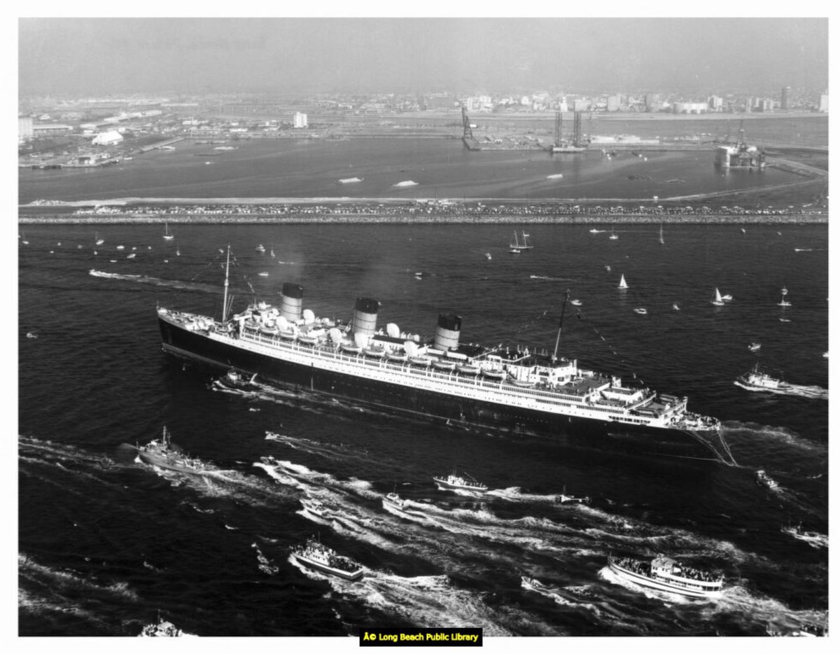 TheQueenMary's tweet photo. Enjoy this 1967 #TBT photo of the historic Queen Mary steamship approaching Long Beach Harbor. Smaller vessels fill the surrounding ocean as they escort her into the harbor. In the background, spectators are watching from parked vehicles on the breakwater. https://t.co/Wlege8rS8R