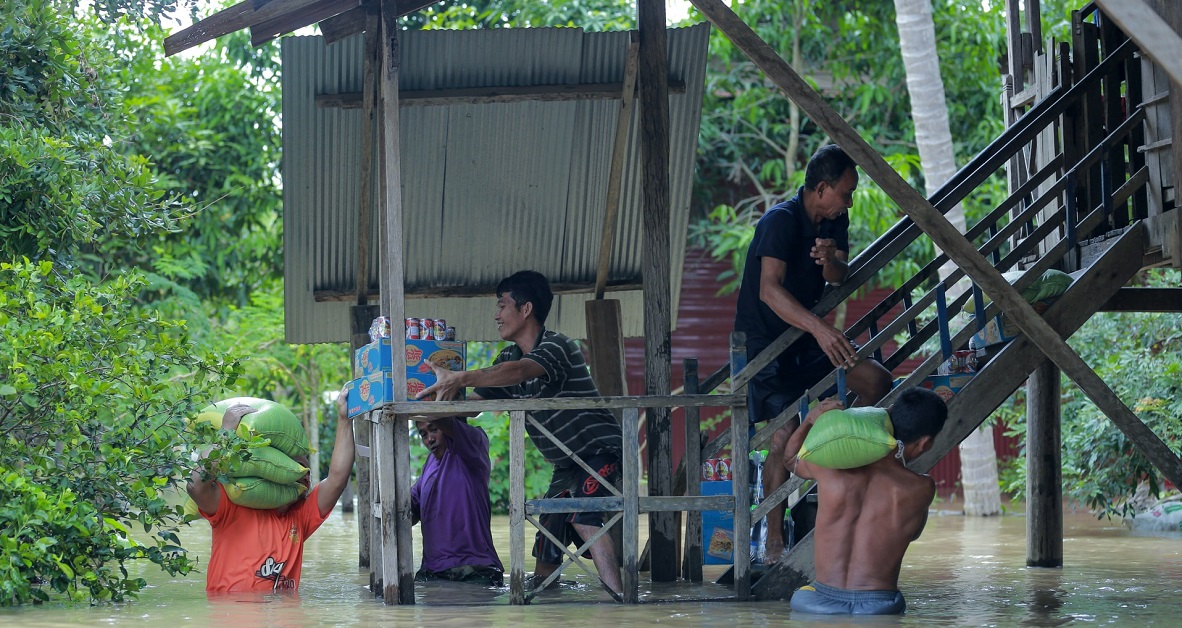 People sharing supplies during a flood in Cambodia. Photo by Ny Menghor on Unsplash.