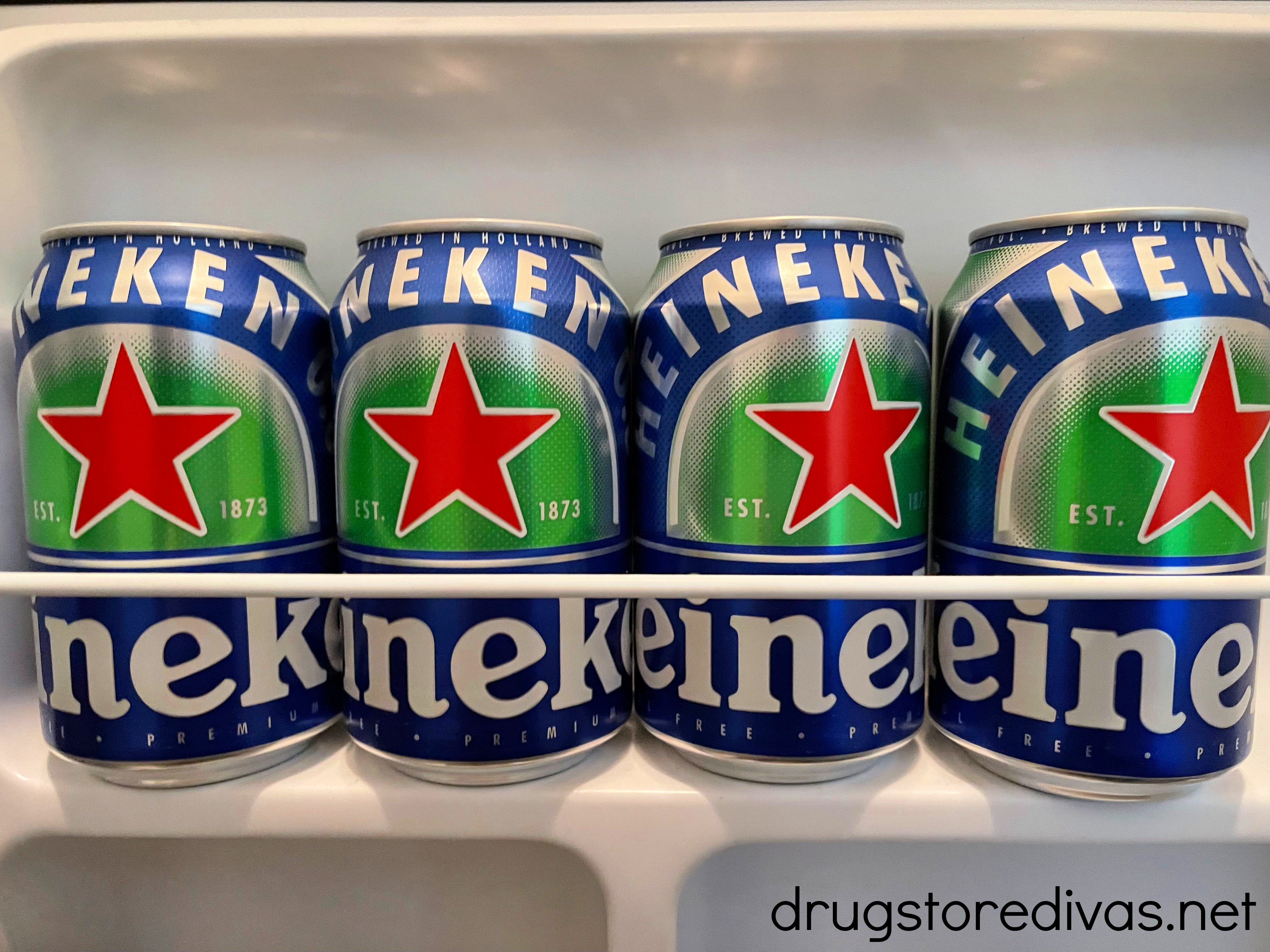 Four Heineken Zero cans in a beer fridge.