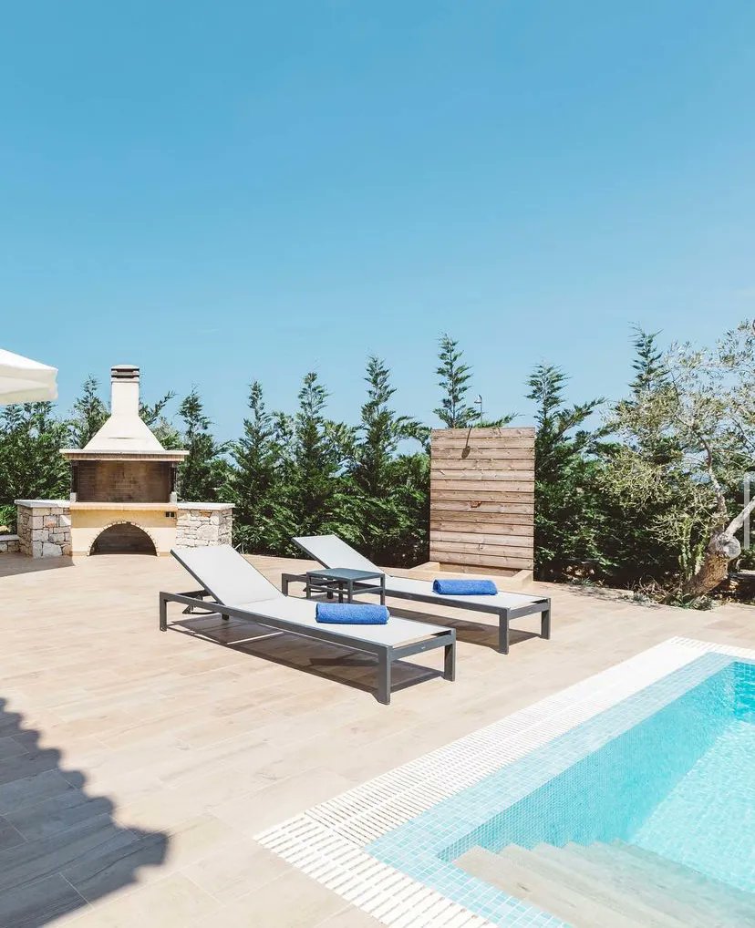 A modest villa, Ilda's charm is in its outdoor spaces. A shaded corner seating area, outdoor BBQ and dining space but in particular the views down to the sea from its idyllic hilltop location. Only a 3-minute drive, call 0207403001 or contact info@peligoni.com to book.