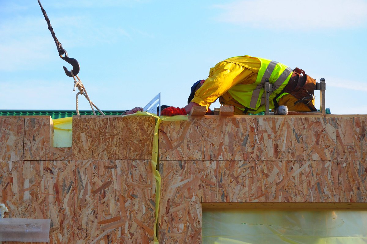 A worker on site with a timber facade panel