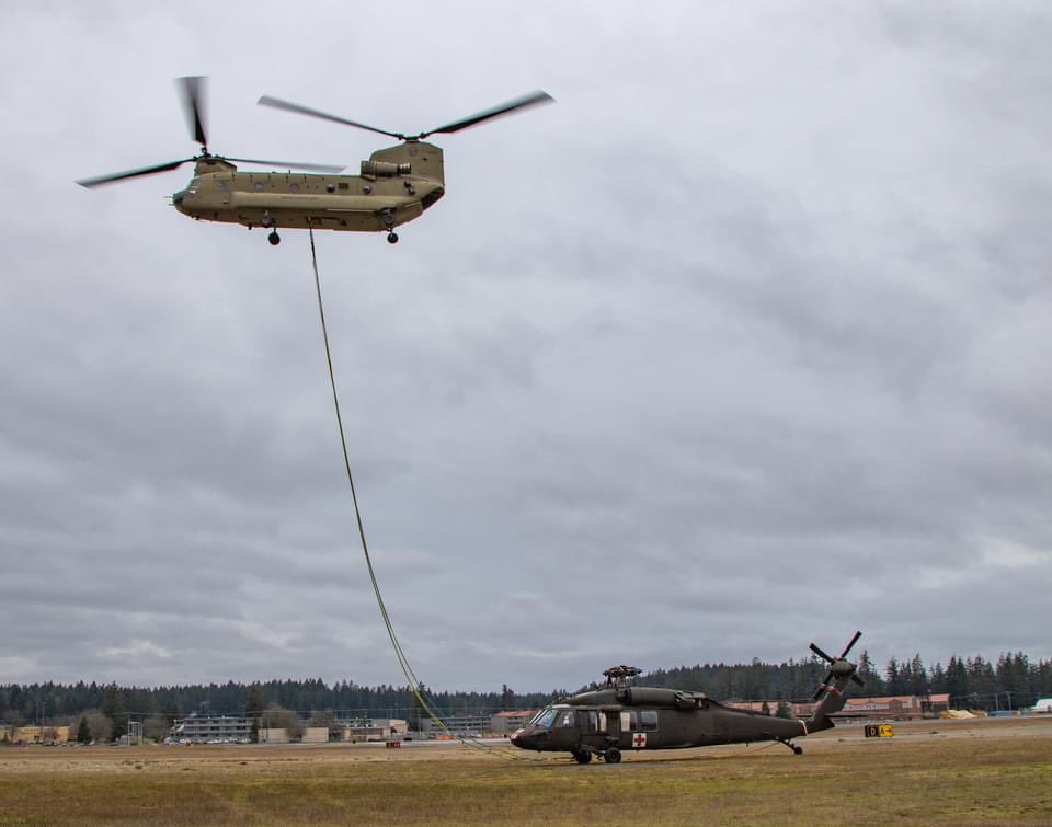 I_Corps's tweet photo. CH-47 Chinooks from @16thCAB and @USArmyAlaska conduct downed aircraft recovery training with a decommissioned UH-60 fuselage to train flight crews for real-world scenarios. #Readiness #GoAviation @7thID https://t.co/AIfdB5pAL5