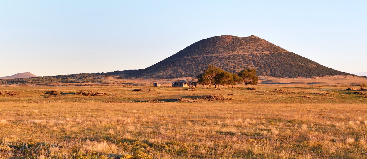Old building and trees in front of Capulin Volcano