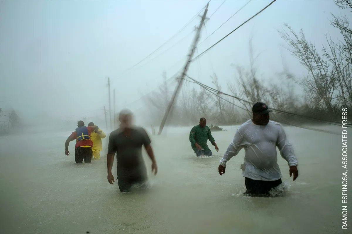 Photo of the Day | Volunteers wade along a flooded road in Freeport, Grand Bahama, after Hurricane Dorian hit the island in September 2019. By Associated Press (@AP) photographer Ramon Espinosa (@AP_respinosa): bit.ly/3ou3gpm