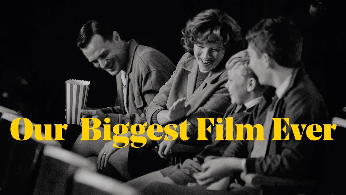 A family having fun in the cinema, text overlaid reads Our Biggest Film Ever