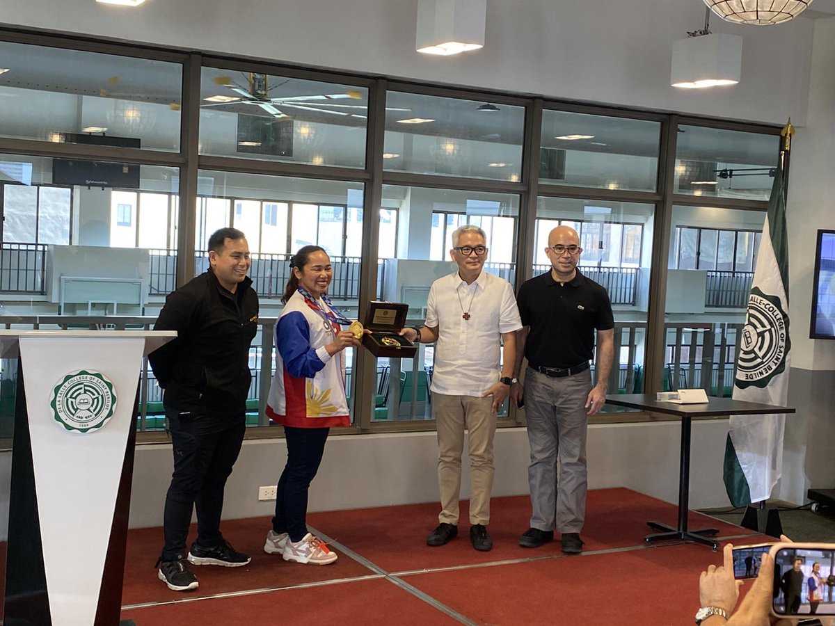 BenildeNews's tweet photo. Happening now: Benilde President Br. Edmundo Fernandez FSC presents Olympic gold medalist and Benilde student Hidilyn Diaz with the Benilde Medallion, the College's highest expression of recognition for an individual or institution's extraordinary achievement or contribution. https://t.co/3Aw1XCge4I