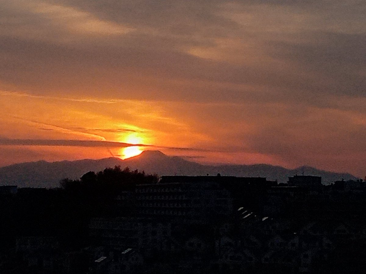torishima's tweet photo. @nhk_radio_news 川崎市の職場から見た富士山の後ろに沈む今日の夕日です。明日、大雪になると思えないきれいな夕焼けです。 https://t.co/VxYdmaM3aI